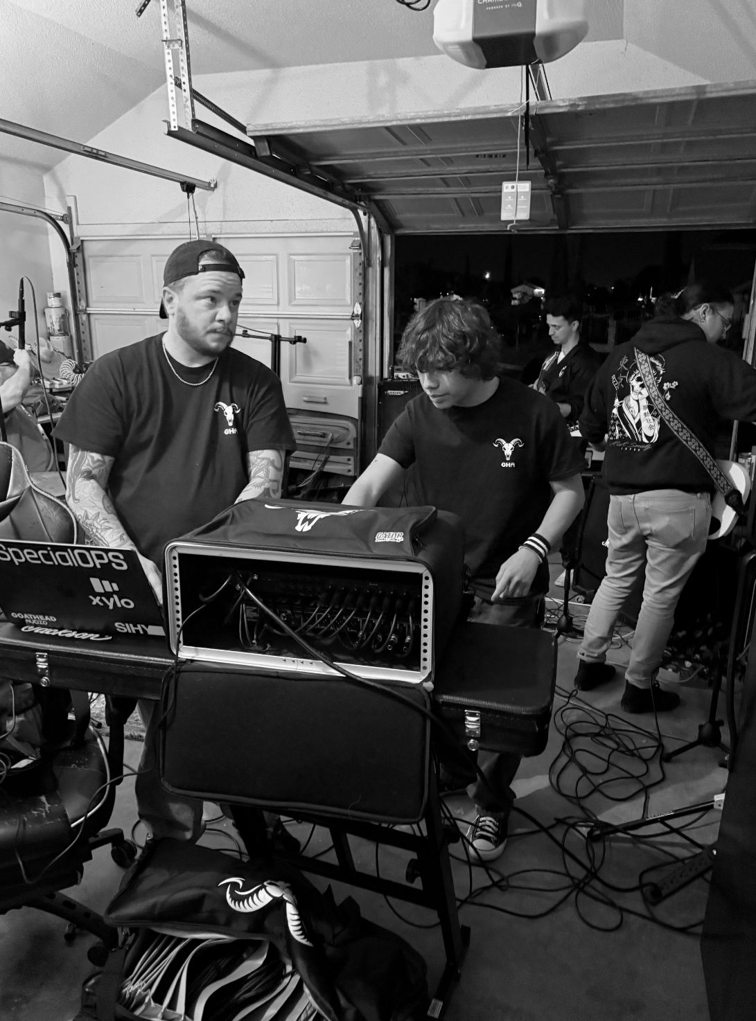 Full band tracking live in a room with drums, guitars, and engineer monitoring the session