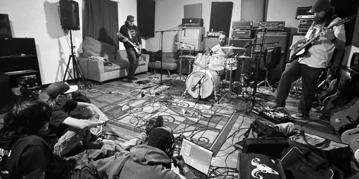 Black and white wide shot of full band recording live in rehearsal room at GoatHead Audio